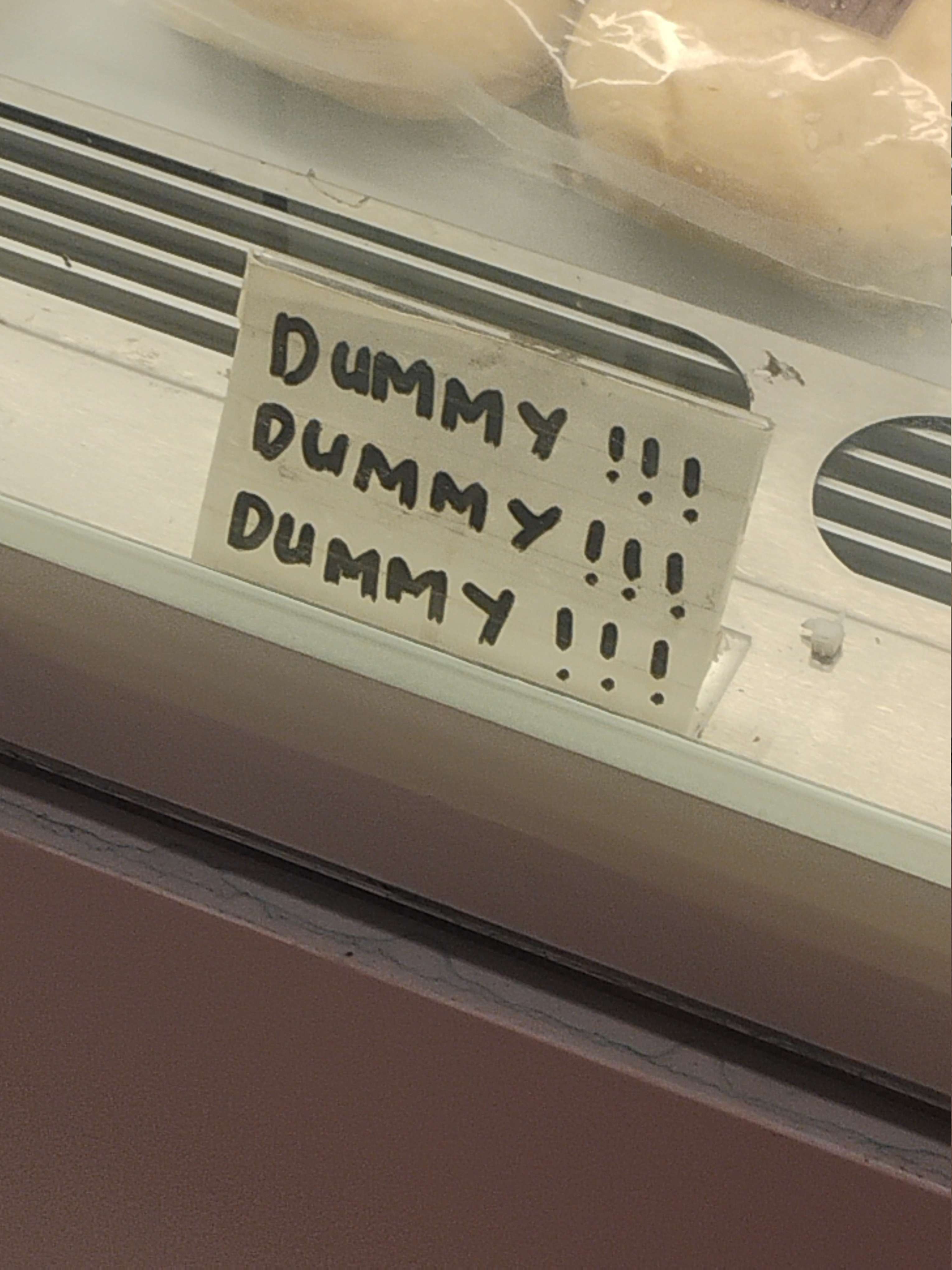 Label stand that has “DUMMY!!!” written on it three times